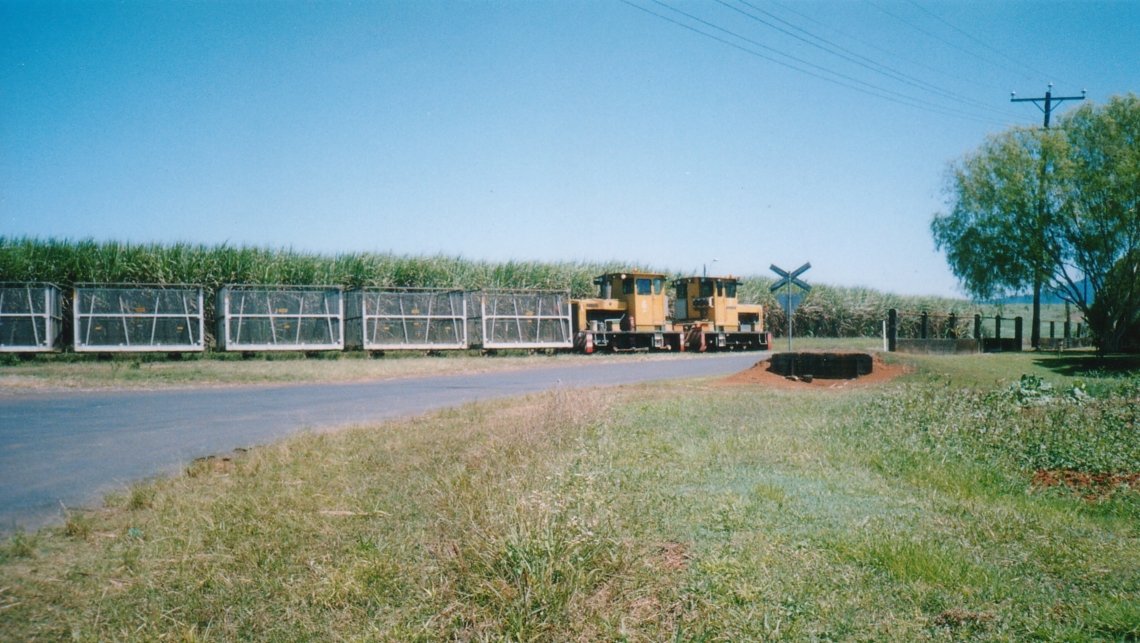 Babinda Mill Locos about to cross the Bruce Highway near Garradunga, 76 km south of Cairns